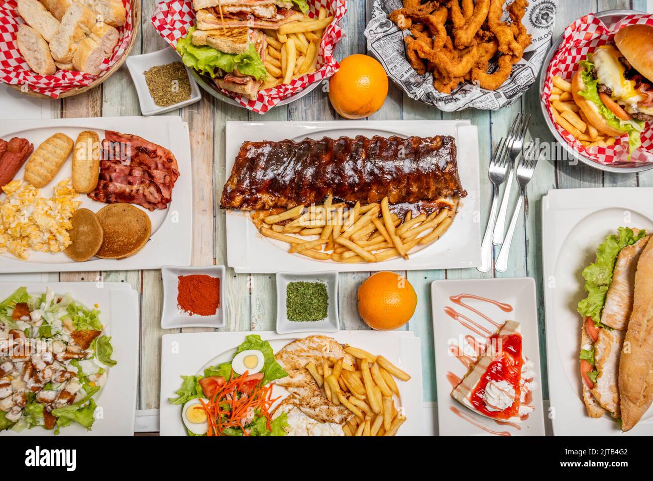 Ricette fast food all'americana, costolette alla griglia, pancake con pancetta e uova strapazzate, hamburger, piatto combinato con pollo, insalata e patatine fritte, Foto Stock