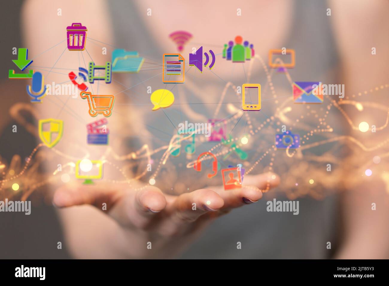 Una donna fuori fuoco che tiene con una ragnatela di icone nel palmo della mano Foto Stock