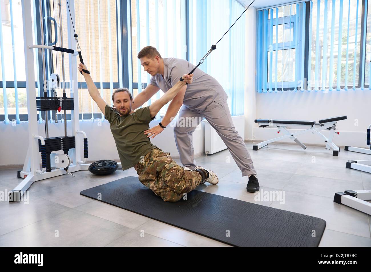 Un istruttore professionista conduce una sessione di terapia riabilitativa Foto Stock