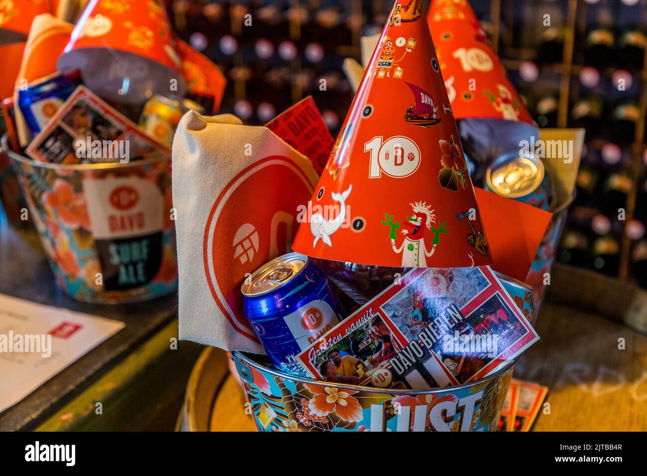 Secchi di metallo stampati a colori della birreria Davo a Deventer, una delle nove città anseatiche storiche sull'IJssel, provincia di Overijssel, Paesi Bassi, con la scritta “Lust for Life”, pronti a celebrare il decimo anniversario della birreria, pieni di cappellini per festeggiamenti, birra in lattina e biglietti di auguri con la scritta “Groeten vanuit Davo Bieren” (Saluti da Davo Bieren). Foto Stock