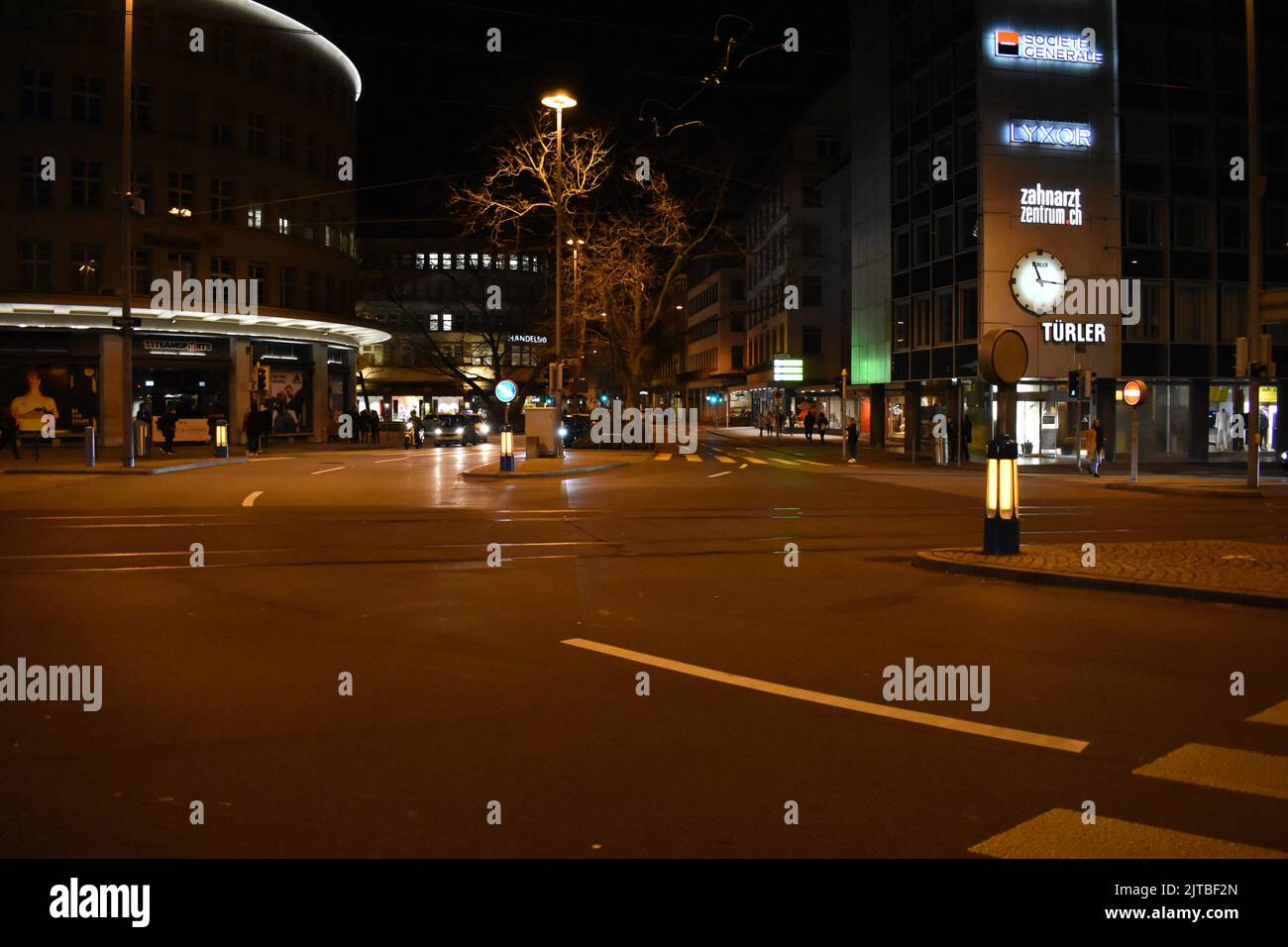 Una bella vista della strada di Zurigo di notte con cartelli e persone che camminano intorno Foto Stock