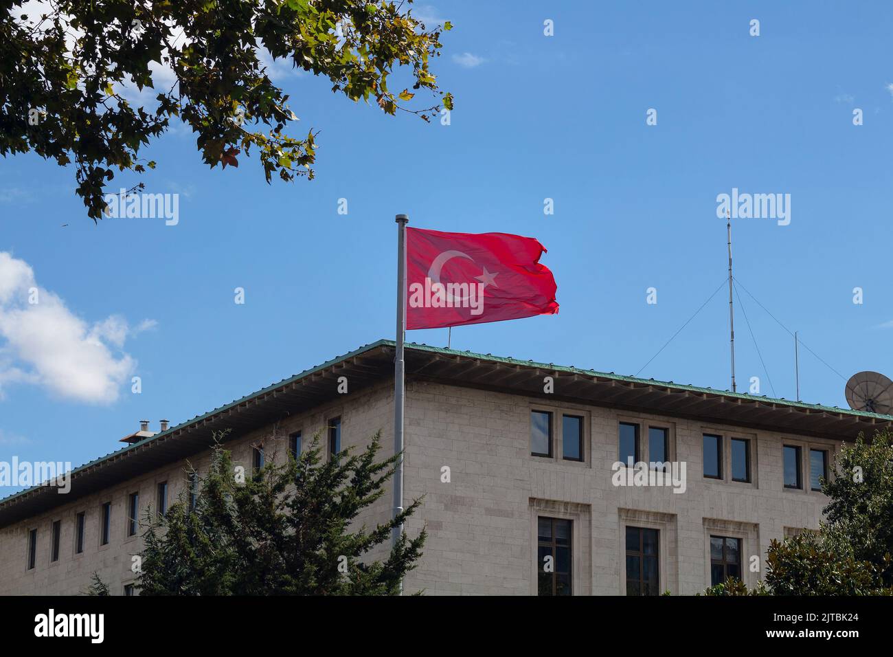 Vista della bandiera turca che sventola di fronte all'edificio della radio di proprietà statale da uno dei viali principali chiamati Halaskargazi nel quartiere Sisli di Istanbul. Esso Foto Stock
