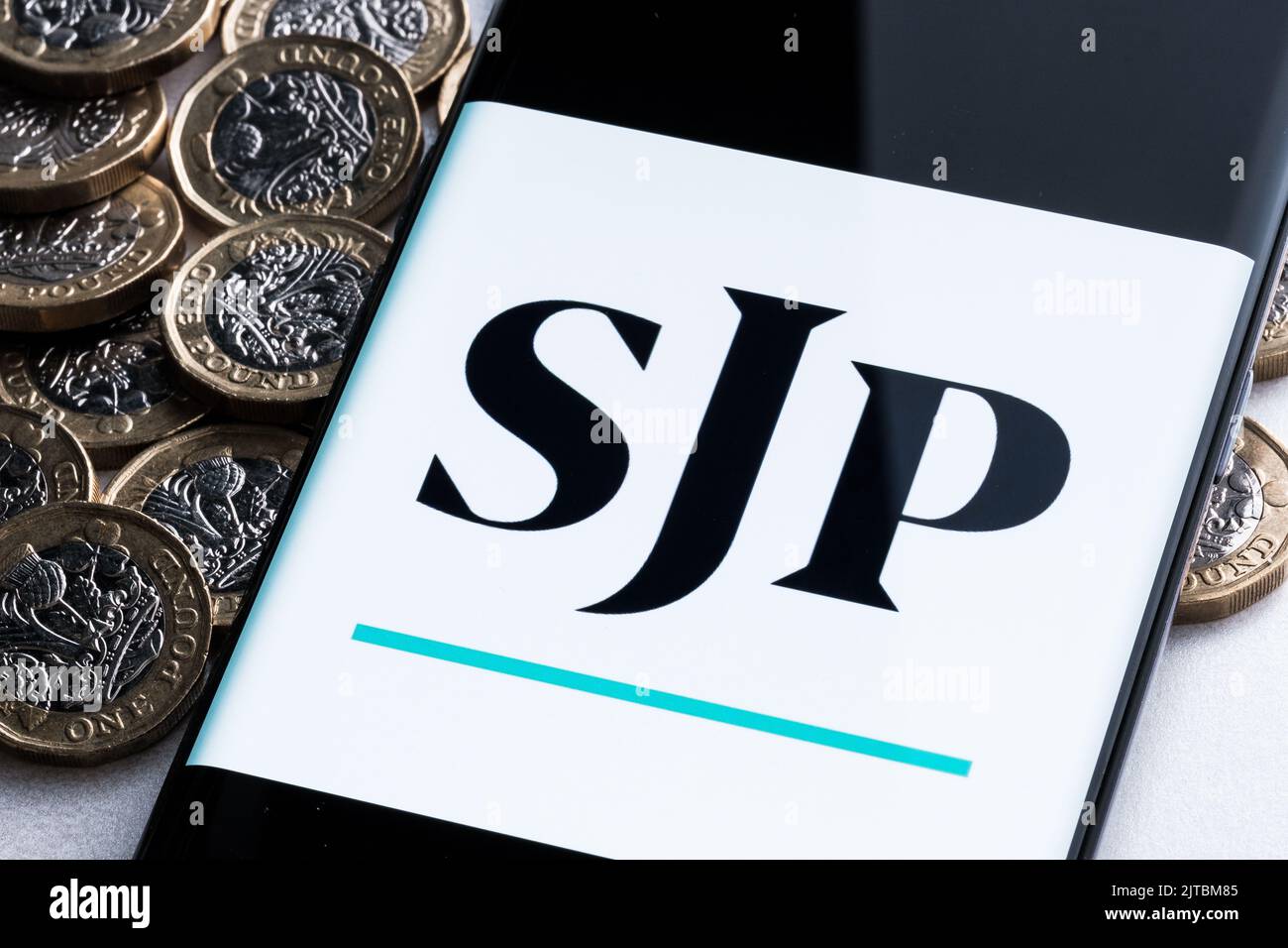 Applicazione SJP visto sullo schermo dello smartphone collocato su monete British Pound. St. James's Place (SJP) è una società di consulenza finanziaria specializzata. Stafford, unità Foto Stock