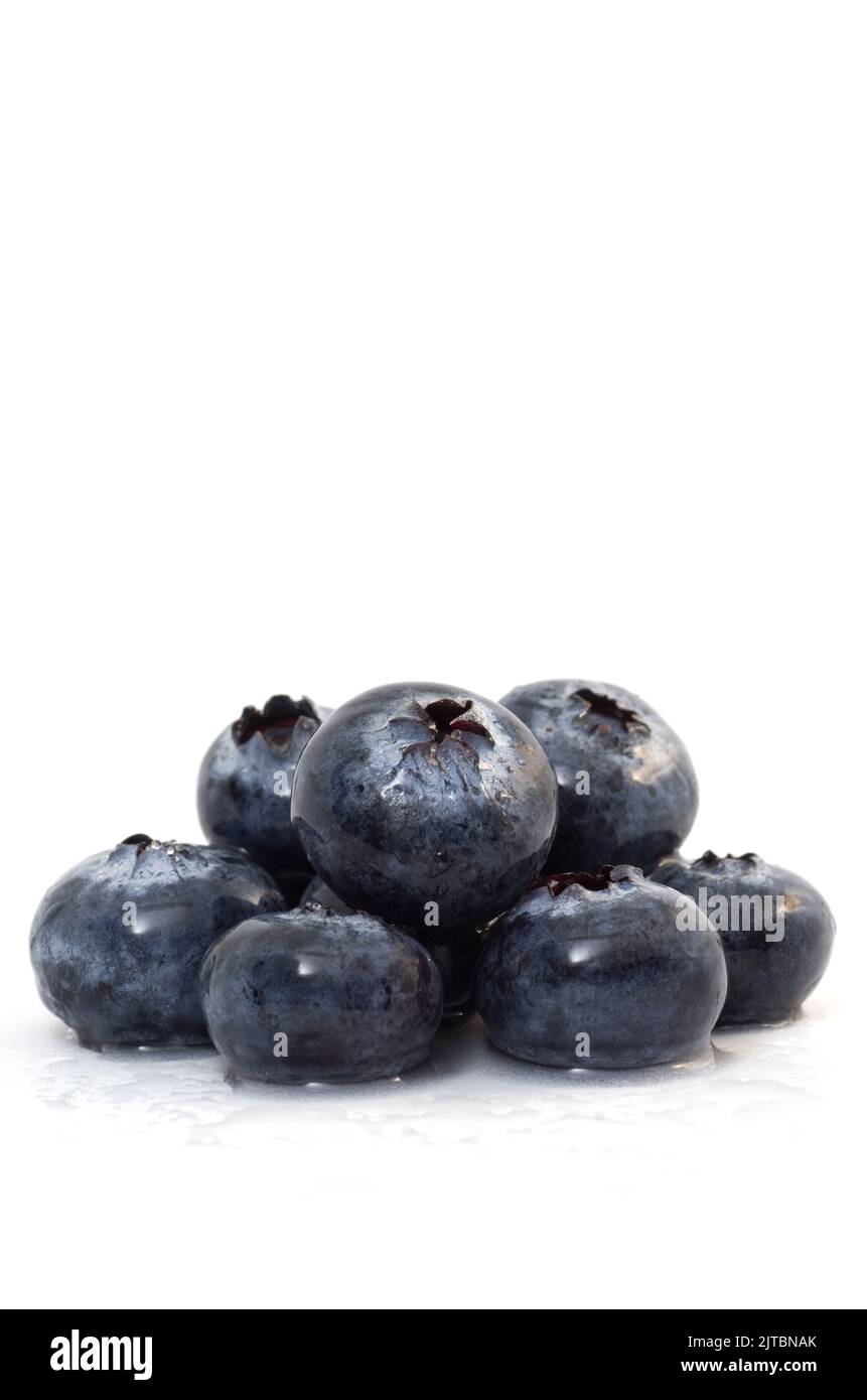 Macro immagine di deliziosi mirtilli umidi isolati su sfondo bianco verticale Foto Stock