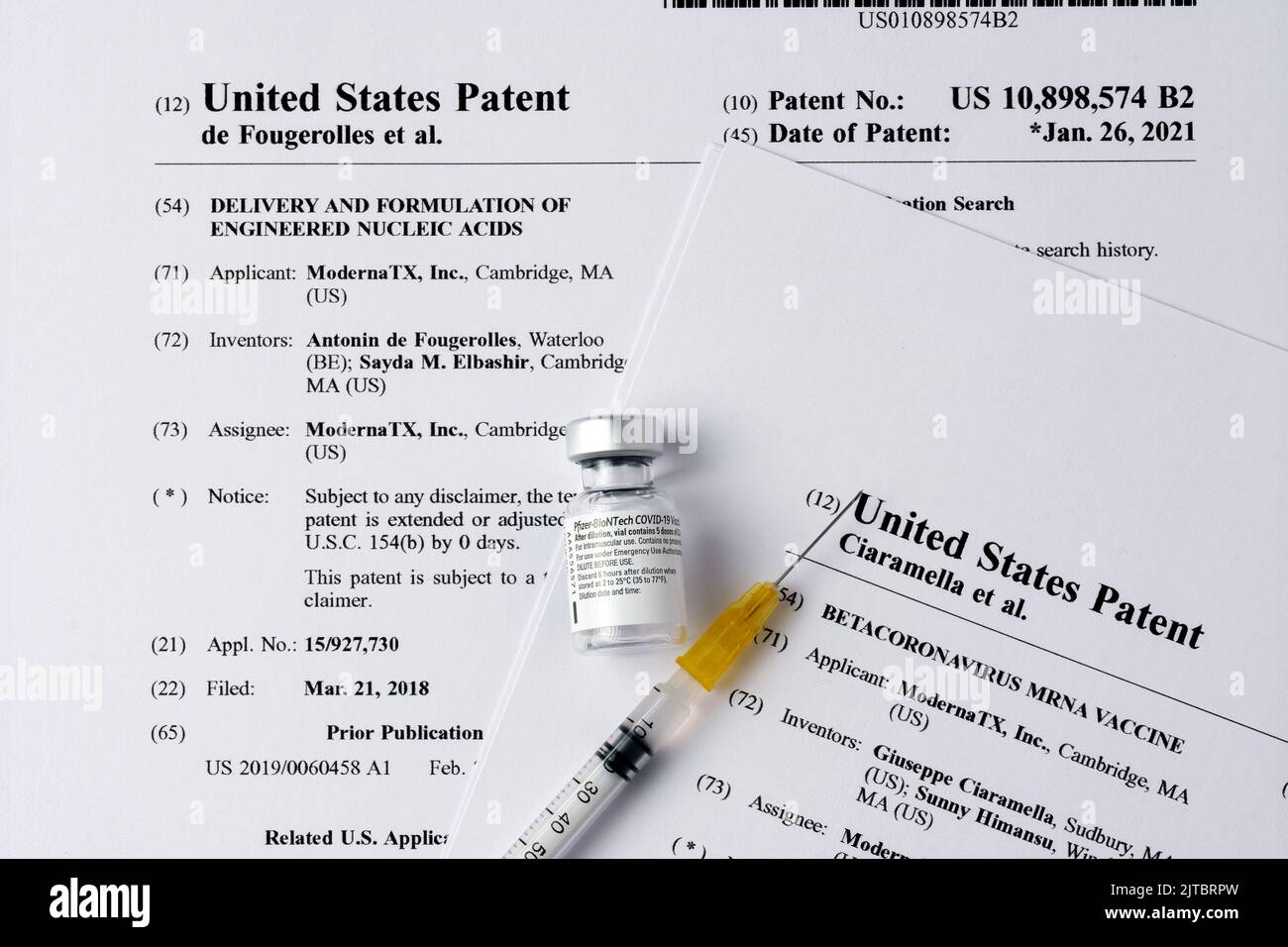 Moderna vs Pfizer Biontech concetto di causa. Flaconcino di vaccino Real PFIZER, siringa inserita nei US10898574 US10933127 brevetti di Moderna che fanno parte di Foto Stock
