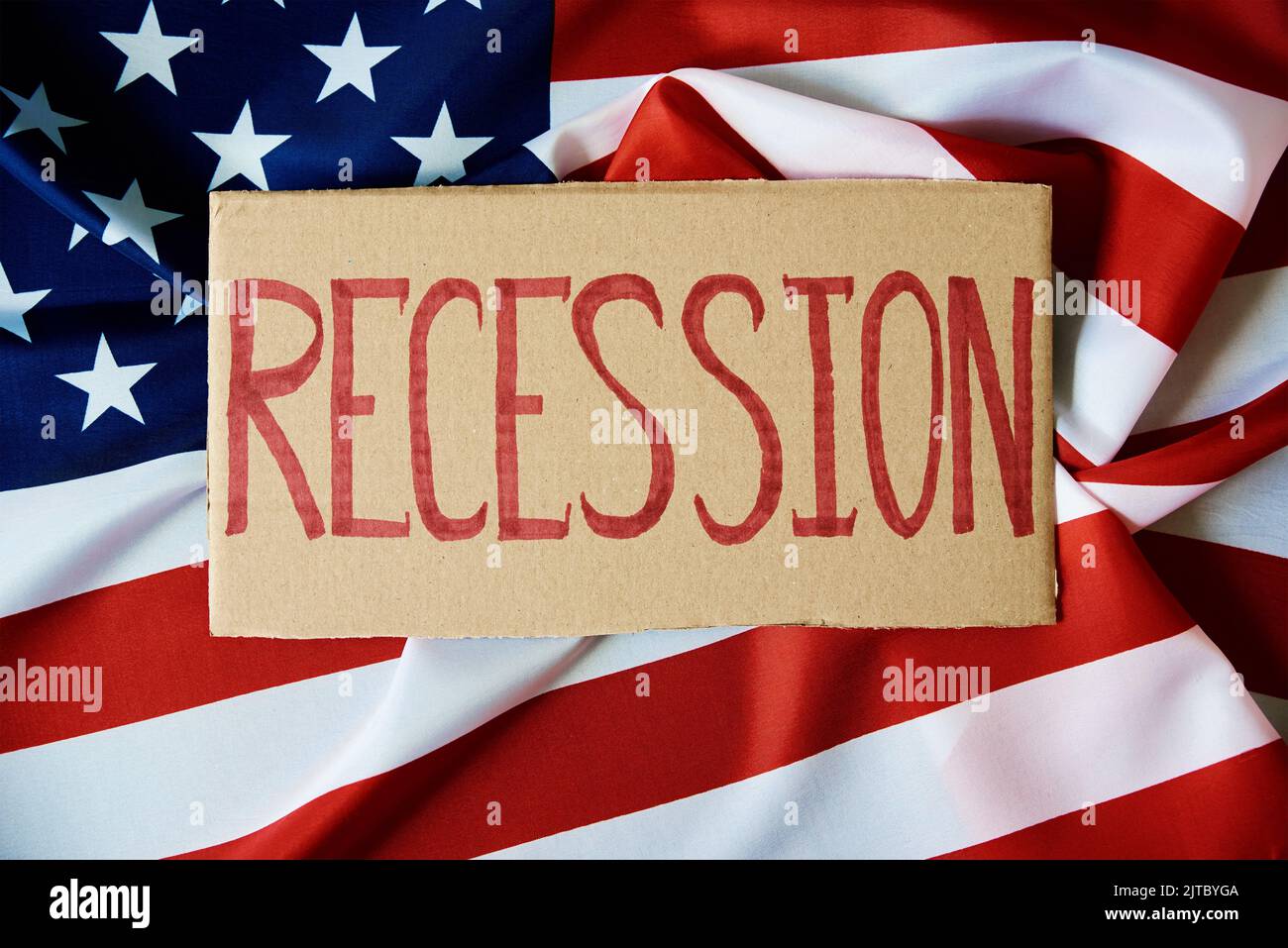 Concetto di recessione e problema finanziario nel sistema bancario degli Stati Uniti e crisi economica mondiale, cartone con parola recessione contro bandiera nazionale americana Foto Stock