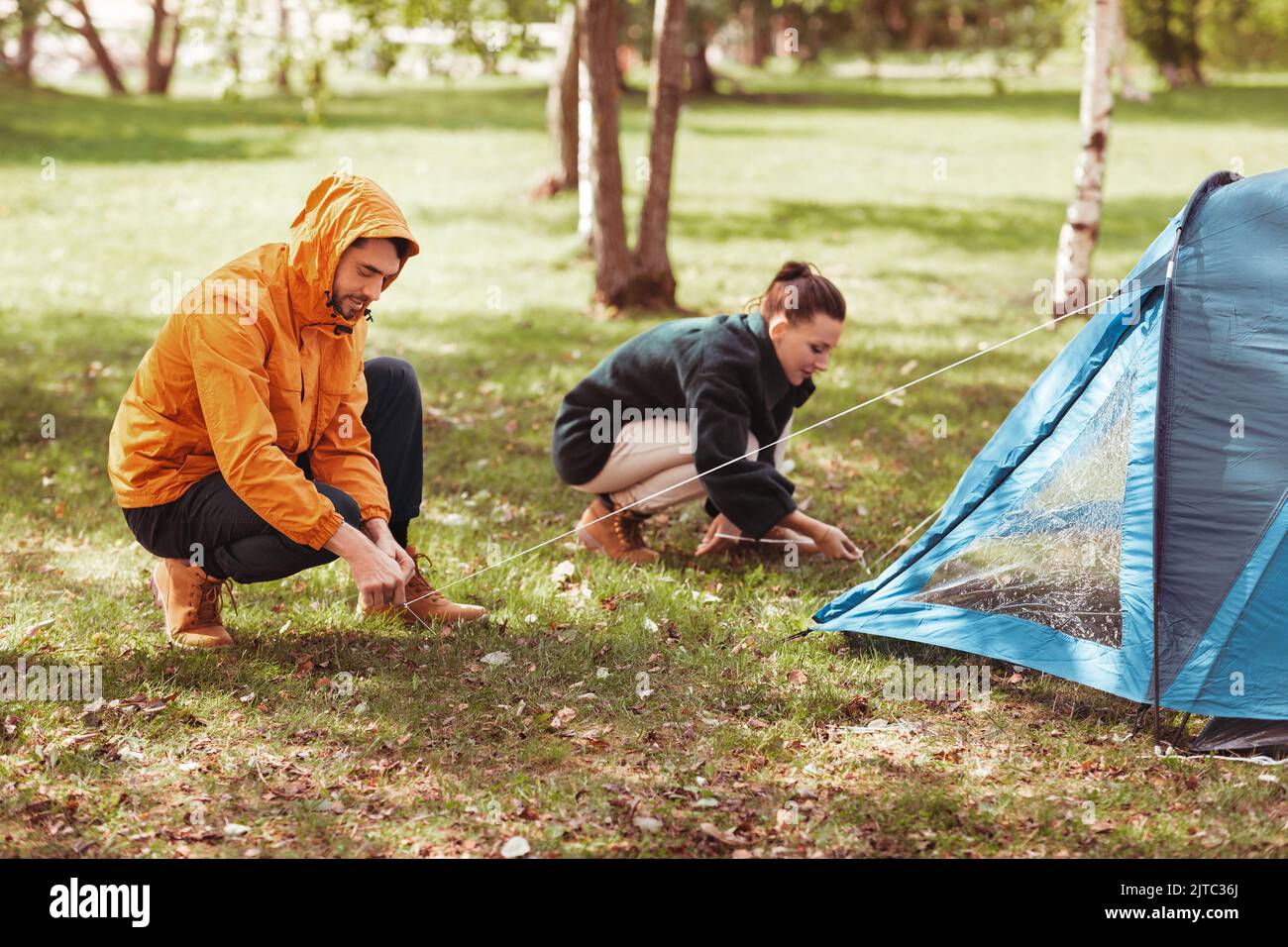 Coppia felice impostazione di tenda all'aperto Foto Stock