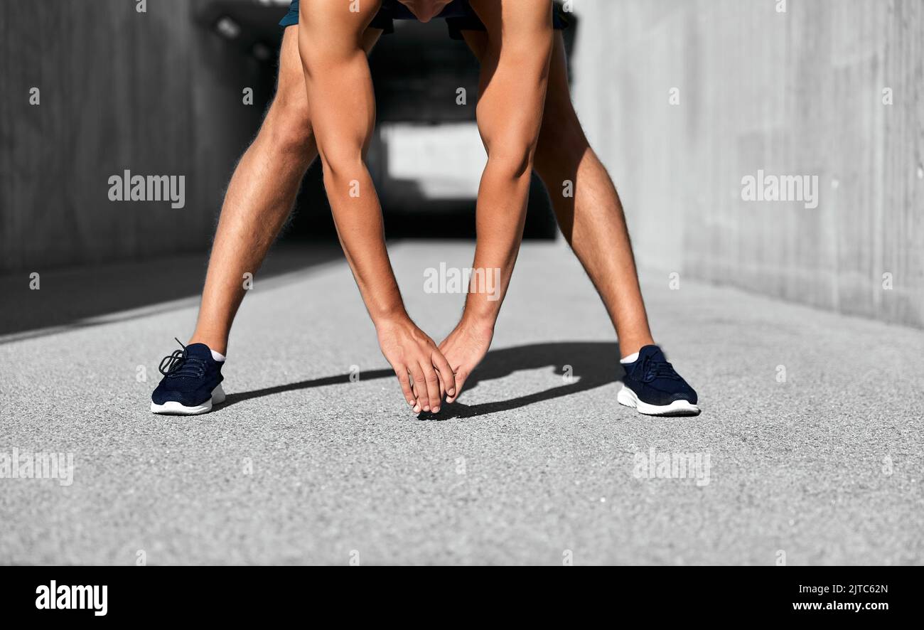 uomo che fa sport e si allunga all'aperto Foto Stock
