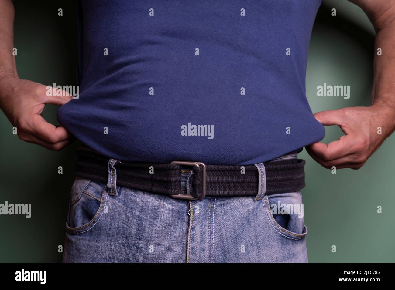 un uomo che tocca i fianchi per misurare lo strato di grasso nel suo corpo. Foto Stock