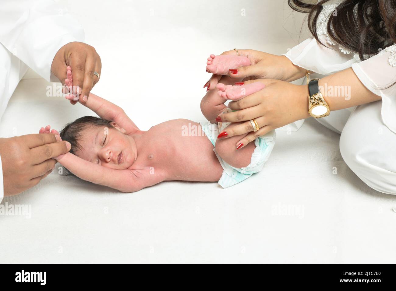 Bambino piccolo ragazzo in mani premurose closeup genitori tenendo neonato famiglia Arabia Saudita esprimendo concetto di fiducia Foto Stock