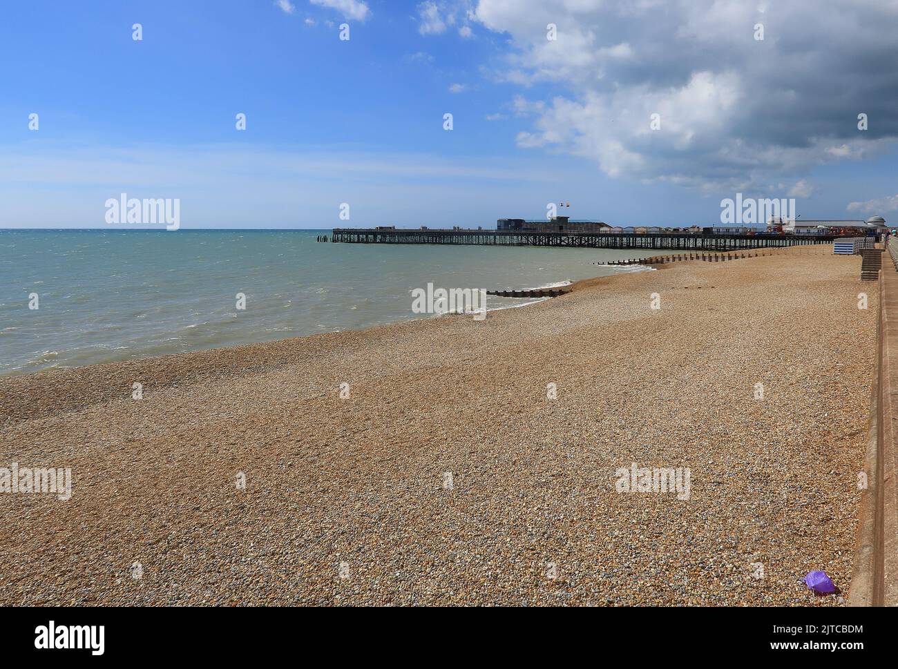 Una vista lungo la spiaggia di ciottoli fino al Molo di Hastings Foto Stock