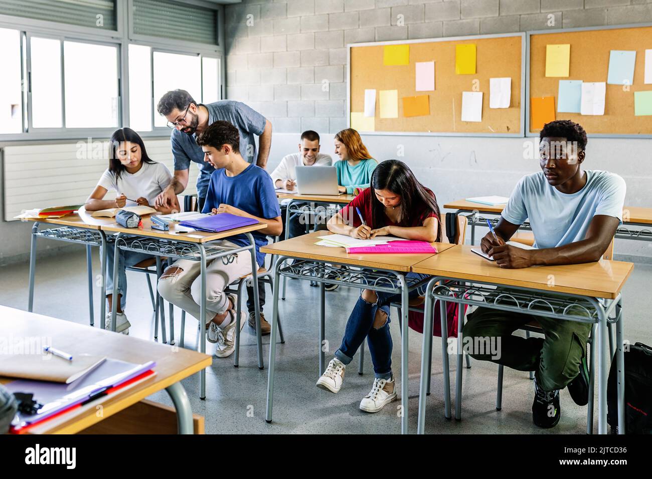 Insegnante di sesso maschile che aiuta gli studenti in classe Foto Stock