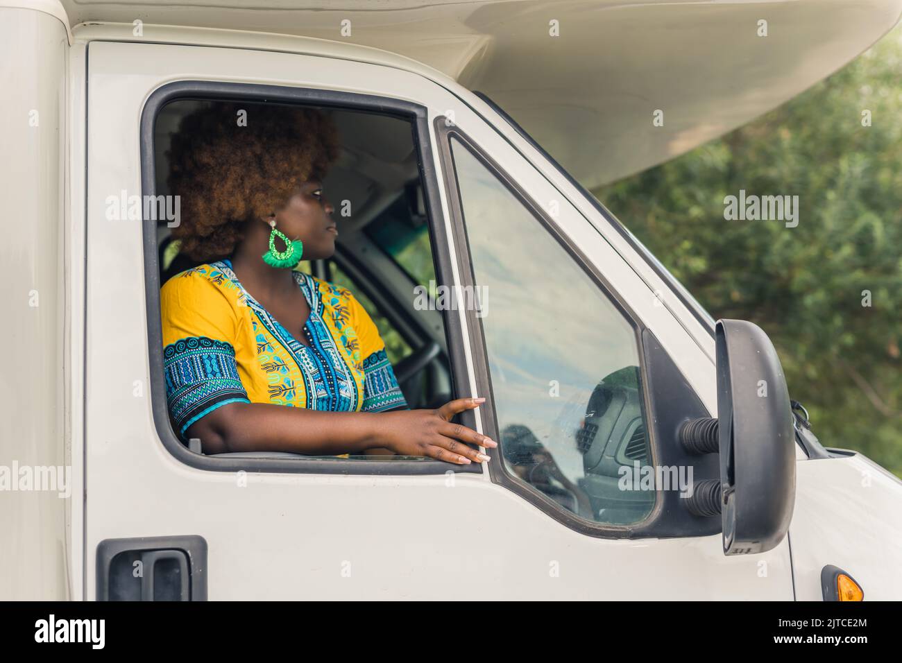Bella afro-americana donna nel furgone guardando il furgone, closeup medio all'aperto viaggio concetto. Foto di alta qualità Foto Stock