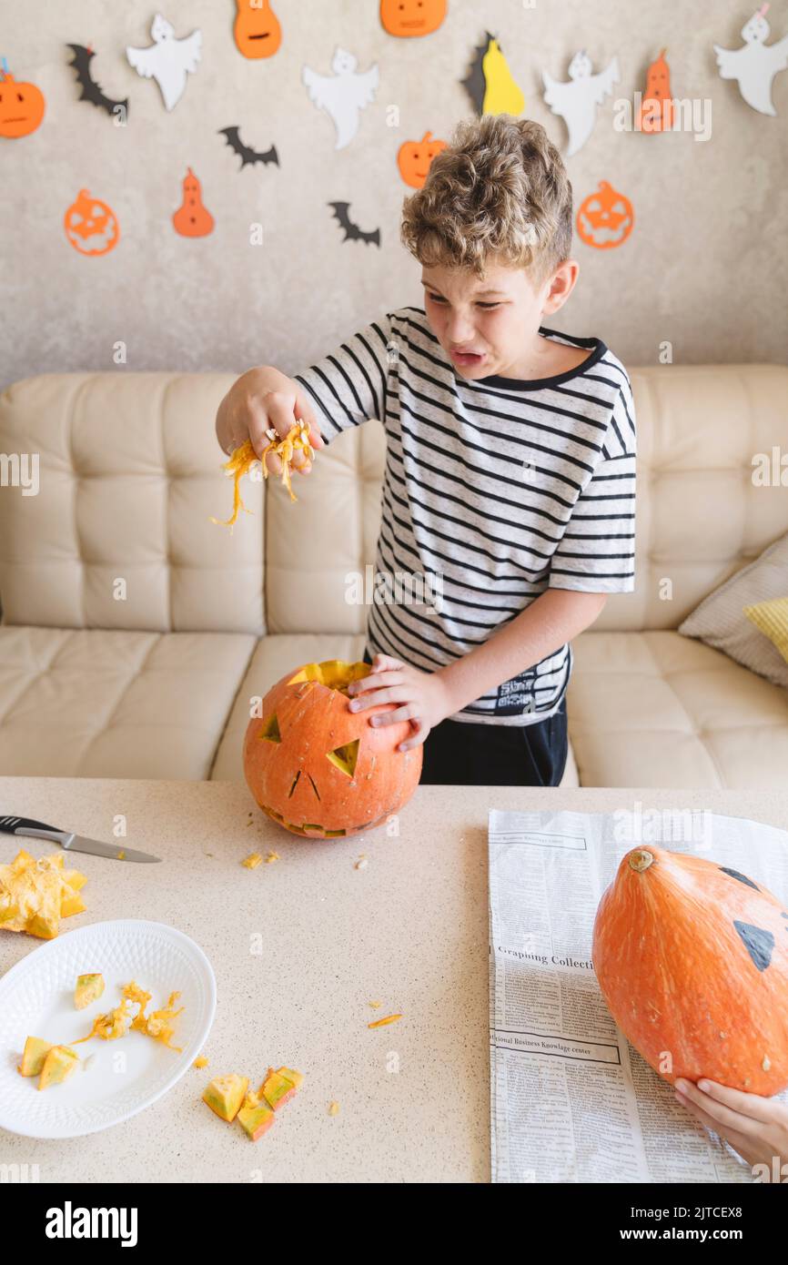 Un ragazzo prepara zucche Jack o lanterna Halloween. Foto Stock
