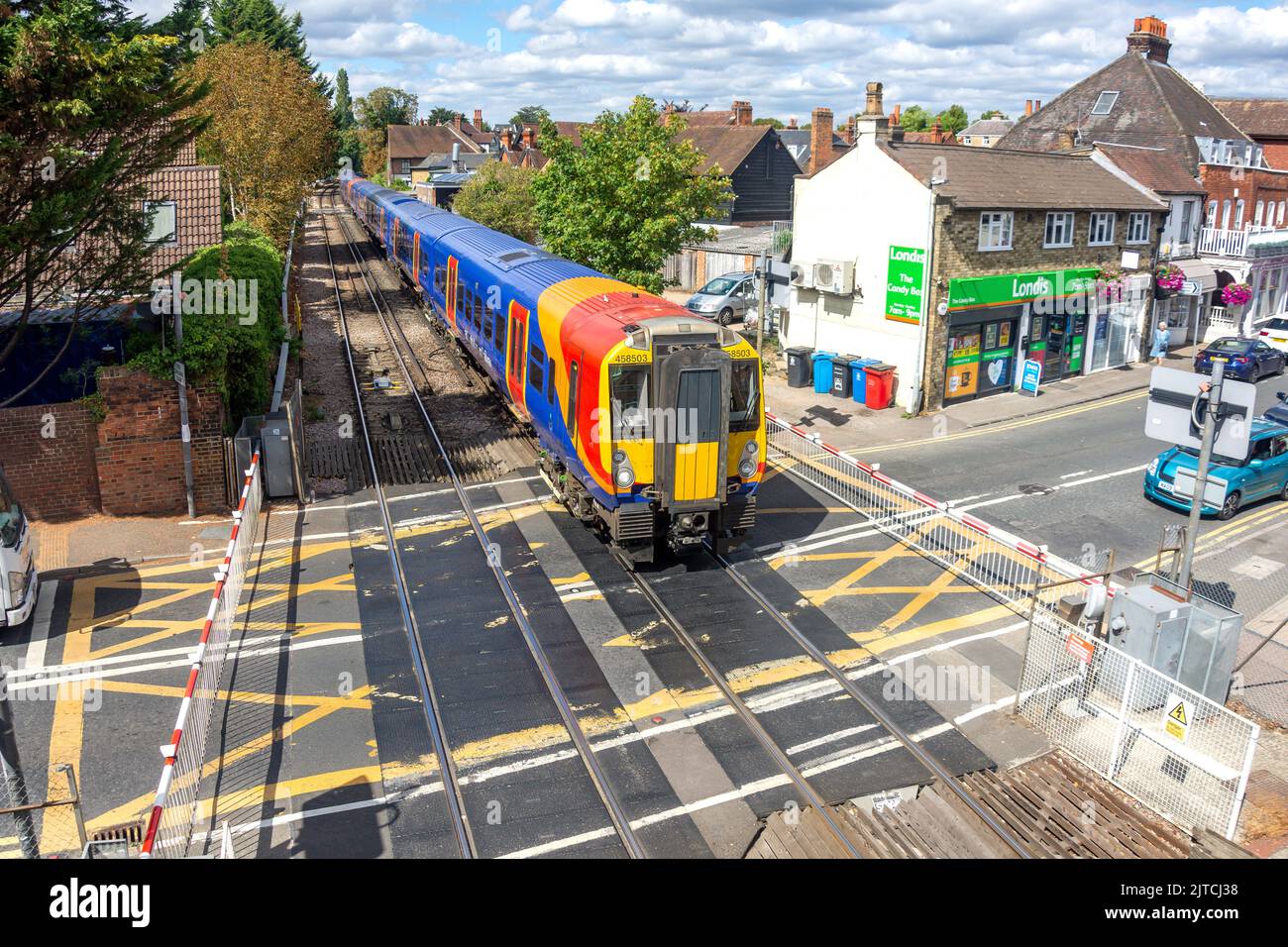 Treno che attraversa la ferrovia alla stazione ferroviaria di Datchet, High Street, Datchet, Berkshire, Inghilterra, Regno Unito Foto Stock