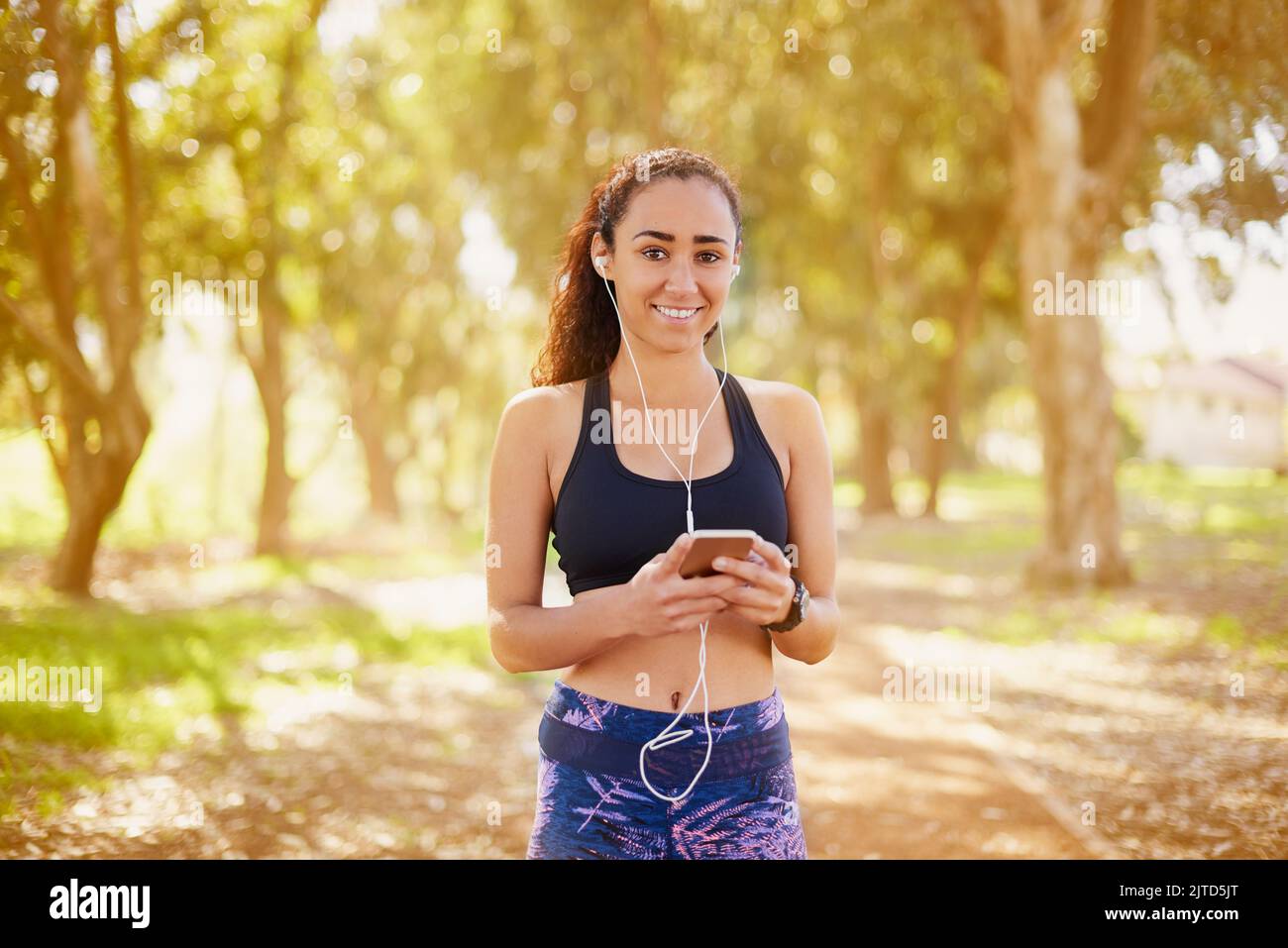 Quando ci si esercita all'aperto si consumano più calorie. Un giovane sportivo che ascolta la musica mentre si lavora all'aperto. Foto Stock