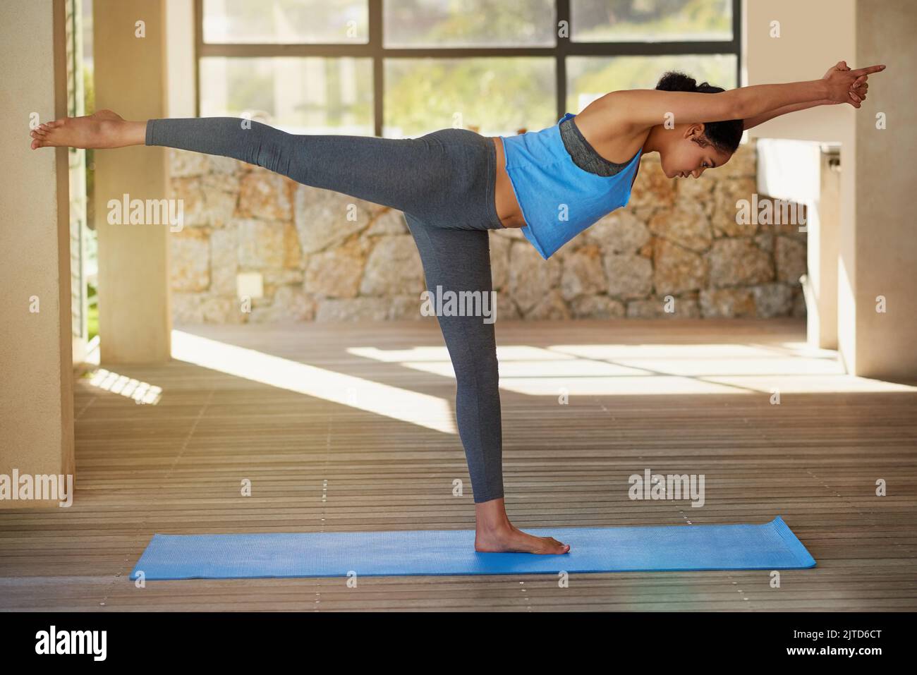 Aumentare la forza muscolare e il tono attraverso lo yoga. Una giovane donna che pratica lo yoga a casa. Foto Stock