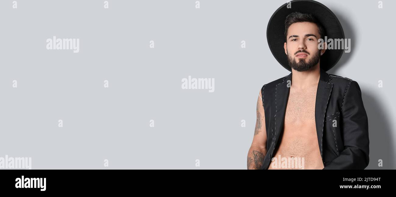 Bel giovane uomo tatuato su sfondo chiaro con spazio per il testo Foto Stock