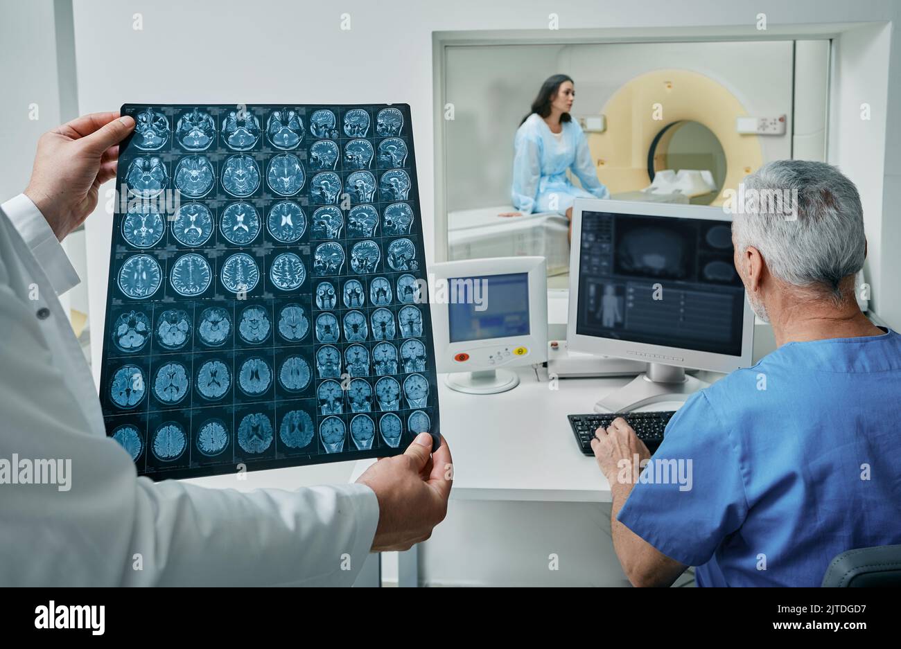 I radiografi che analizzano i risultati della scansione TC della testa del paziente si trovano nella sala di controllo del reparto di radiologia dell'ospedale. TC o MRI del cervello umano Foto Stock