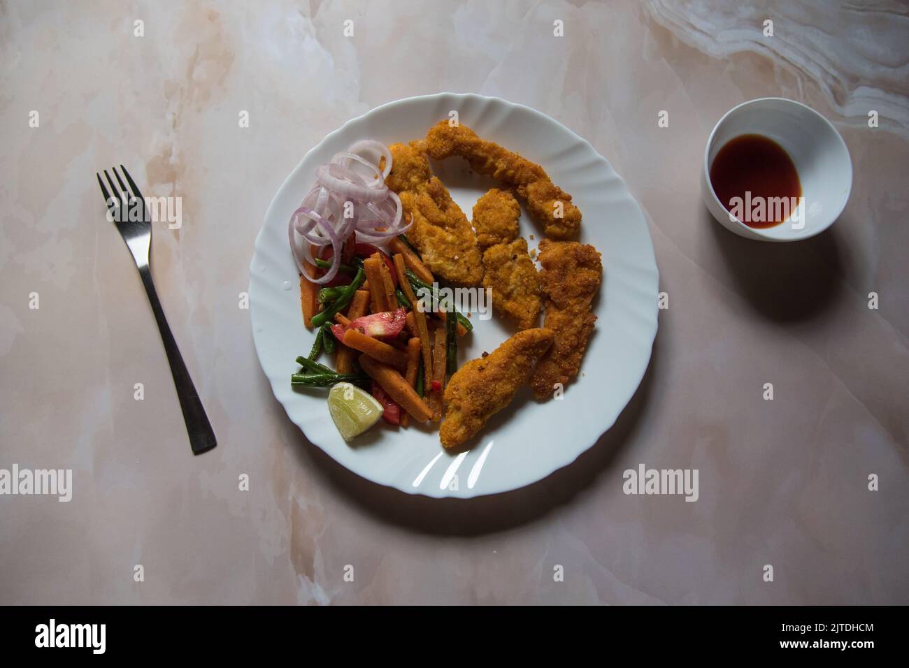 Vista dall'alto delle ali di pollo fritte e dei condimenti in un piatto bianco. Foto Stock