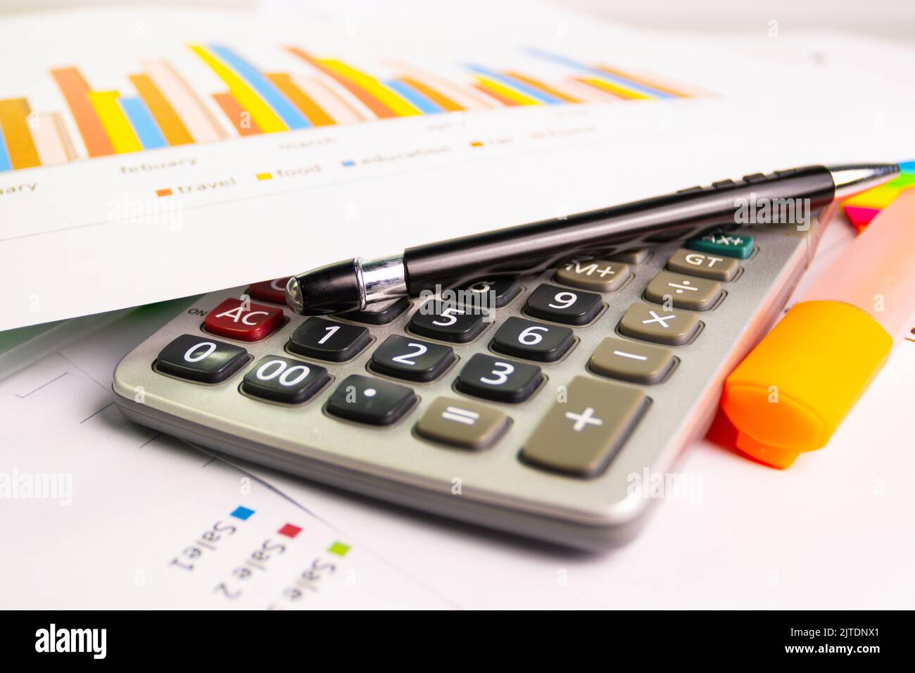 documentare il foglio grafico a colori per la presentazione in ufficio con la calcolatrice delle attrezzature, la penna, la penna a colori evidenziata Foto Stock