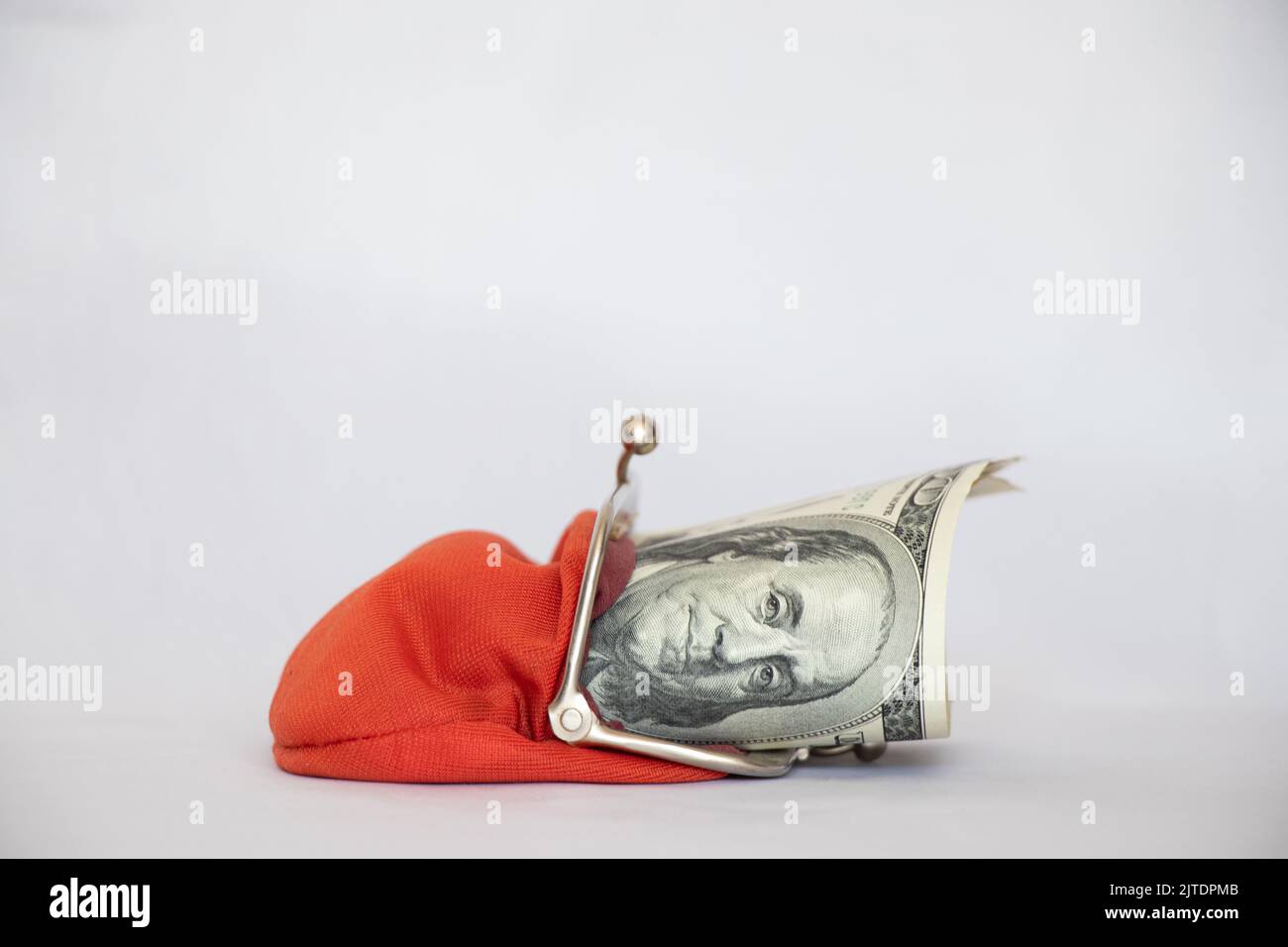 Cento dollari si trovano in un portafoglio rosso su un fondo bianco, finanza ed economia Foto Stock