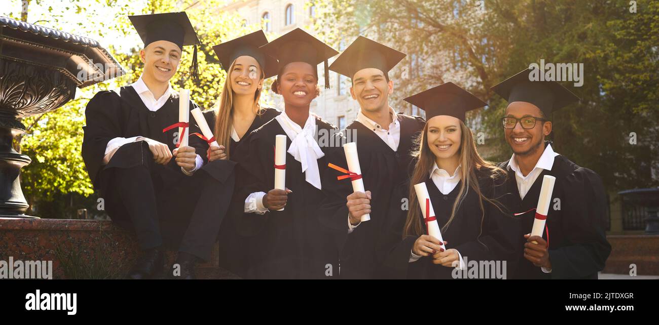 Gioioso gruppo di studenti multirazziali che insieme hanno ricevuto il diploma di laurea e di educazione. Foto Stock