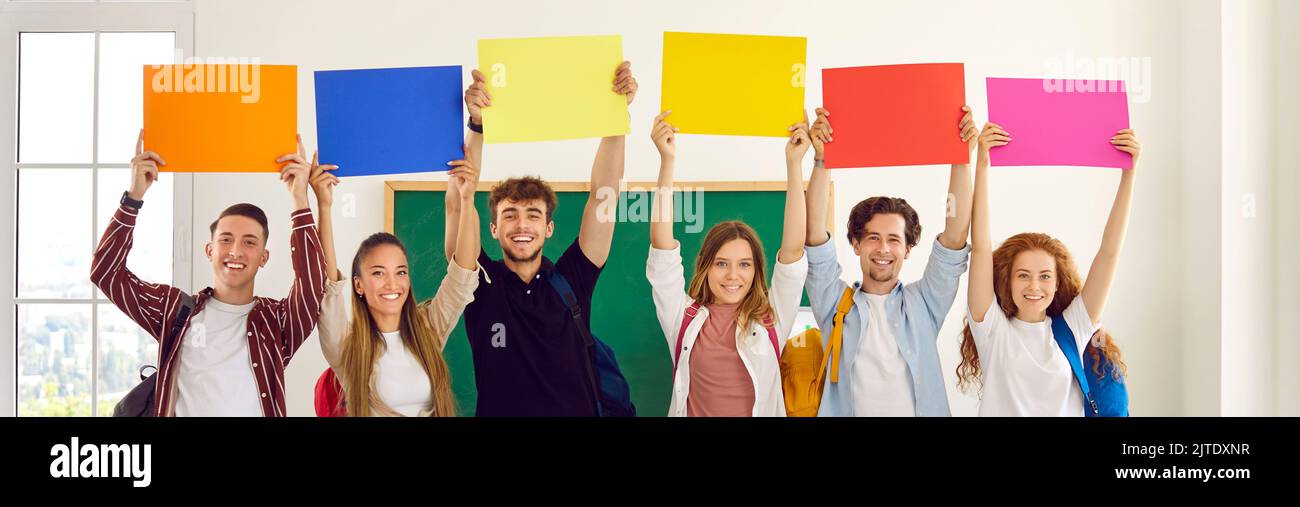 Gruppo di studenti felici e sorridenti della scuola o dell'università che hanno striscioni colorati mockup Foto Stock