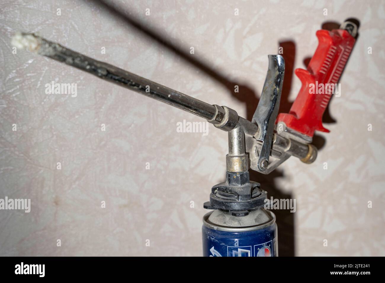 montaggio della pistola per schiuma e del cilindro per schiuma sul ripiano in officina Foto Stock