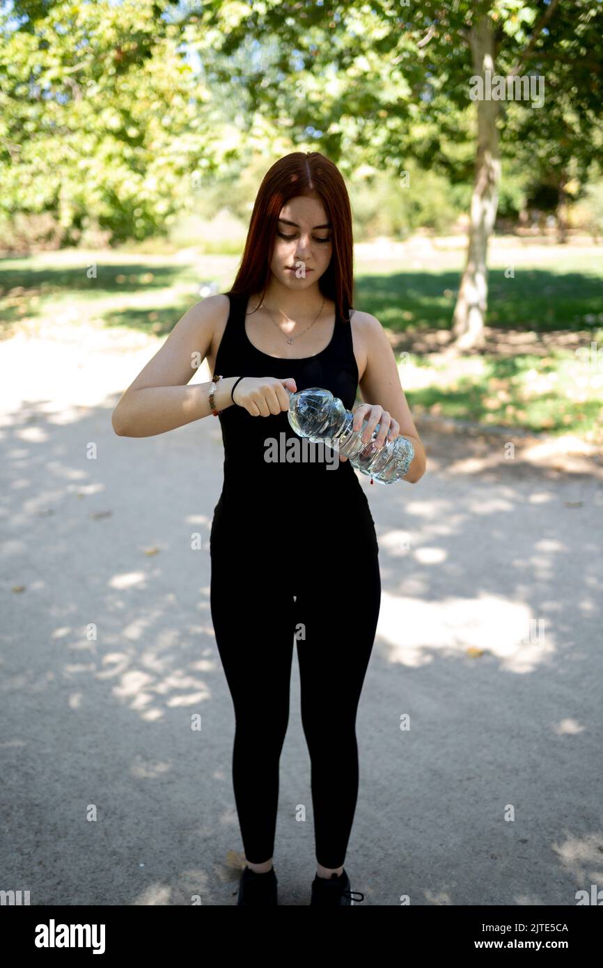 Sportivo con bottiglia d'acqua all'aperto in un parco pubblico. Foto Stock