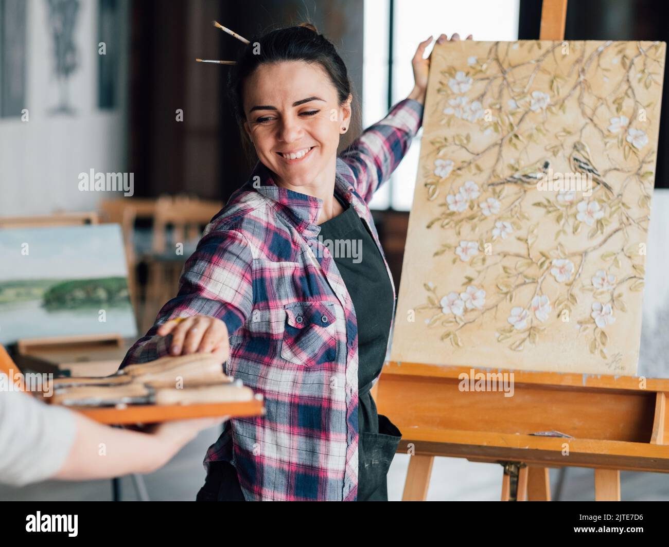 felice donna artista pittura aiuto assistenza Foto Stock