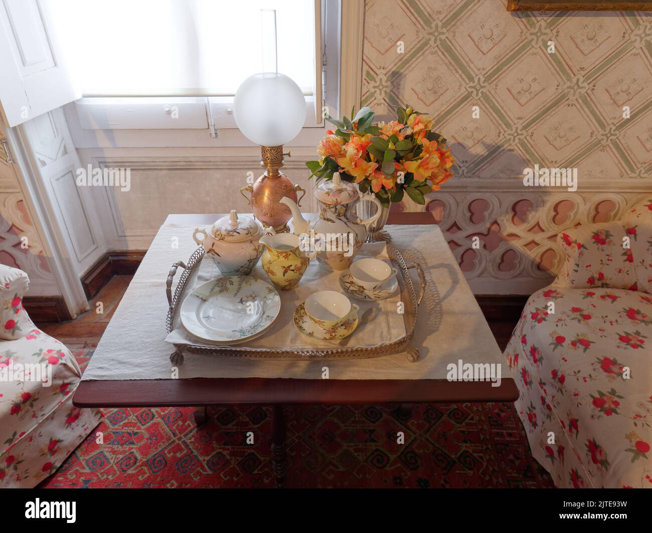 Salotto con vassoio di tazze e tea pot, lampada e fiori all'interno del Palácio da pena, Sintra, quartiere di Lisbona, Portogallo. Foto Stock