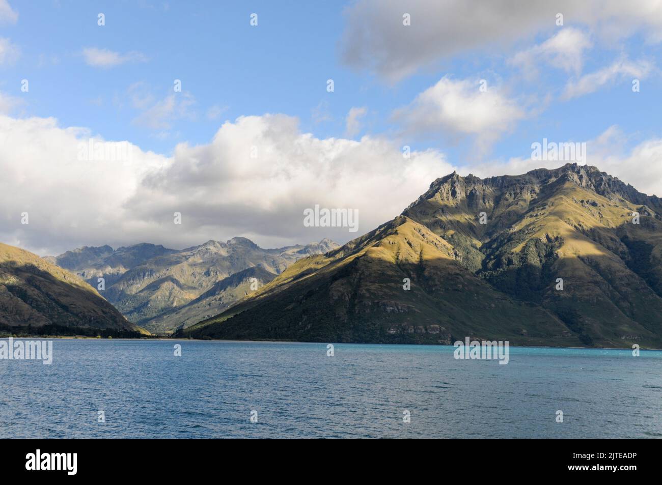 Luce e ombra mattutine sulle montagne sulle rive del lago Wakatipu nell'entroterra di Otago, una regione sud-orientale sull'Isola Sud della Nuova Zelanda. Foto Stock