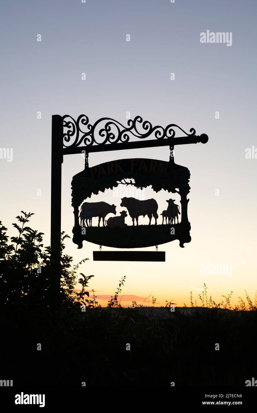 Park Farm segno con Stow on the Wold nella distanza, Cotswolds, Gloucestershire, Inghilterra. Silhouette Foto Stock