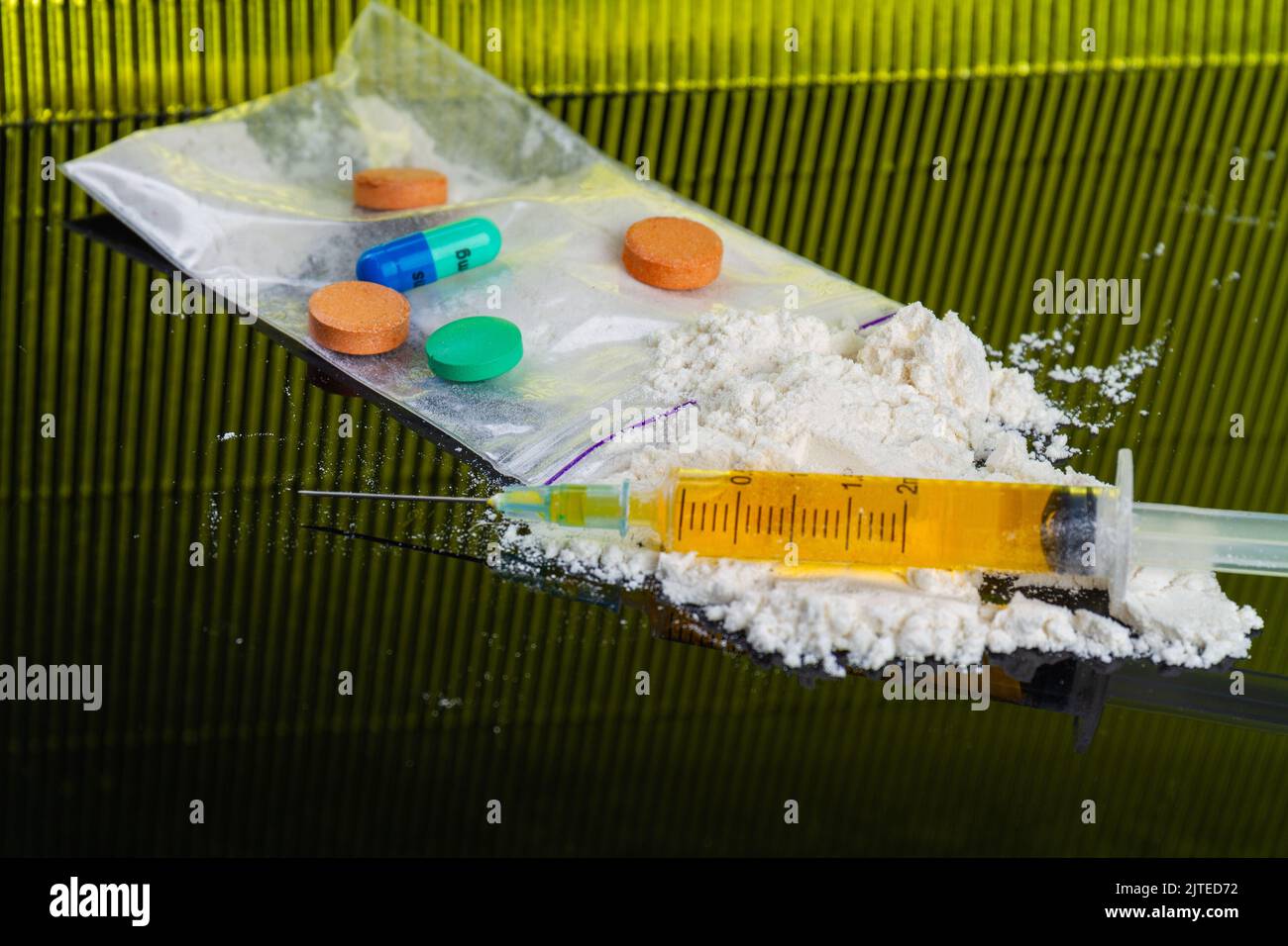Compresse colorate e pillole con siringa e cocaina in polvere. Molte droghe varie. Foto Stock