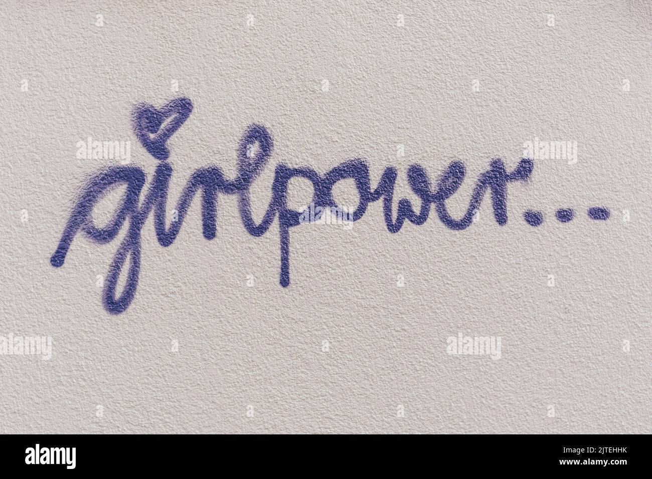 Scrivere 'girlpower' su una parete di casa intonacata Foto Stock