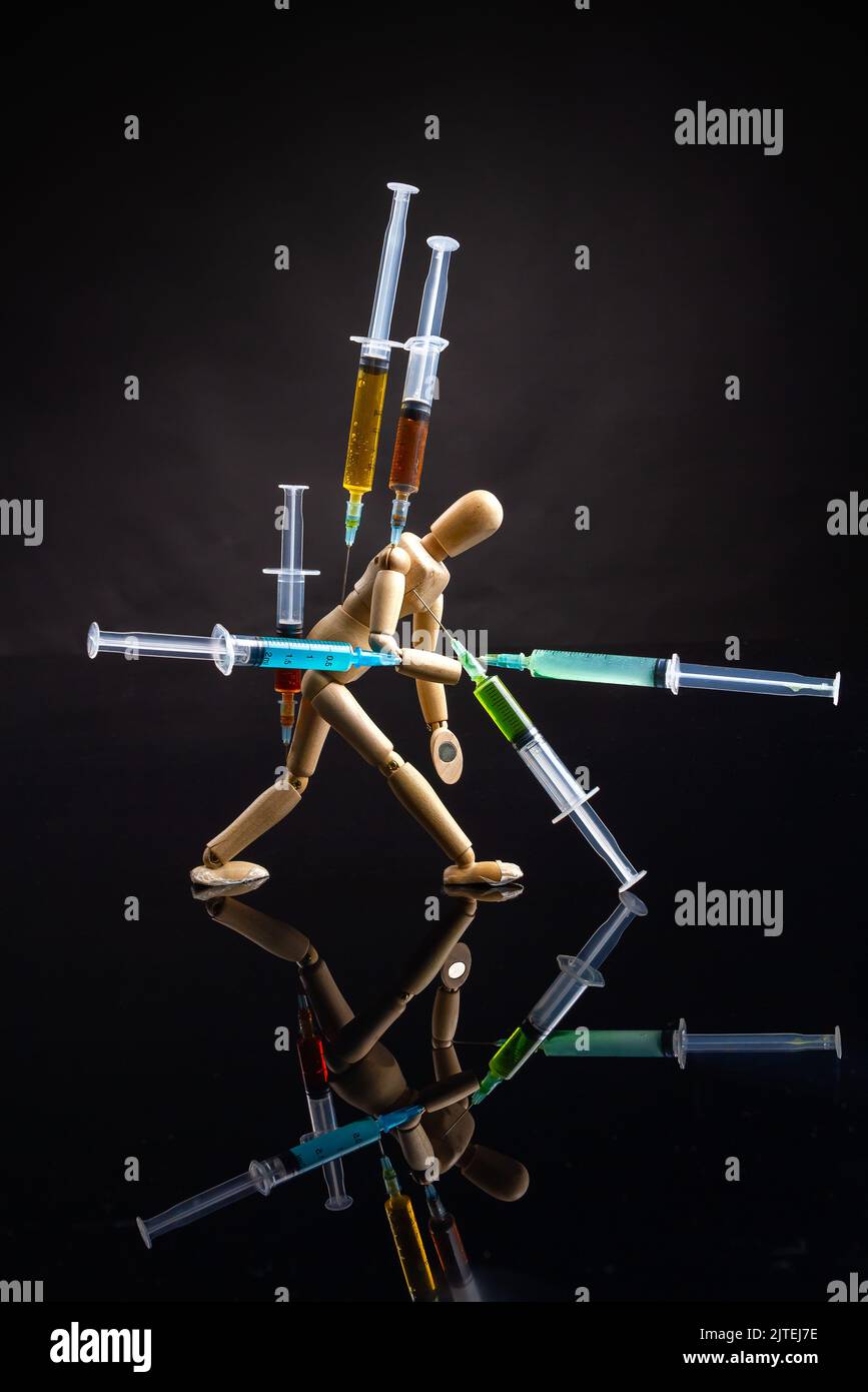 Concetto di dipendenza da droga e overdose dell'oggetto dell'arte. Foto verticale di manichino in legno su sfondo nero. Foto Stock