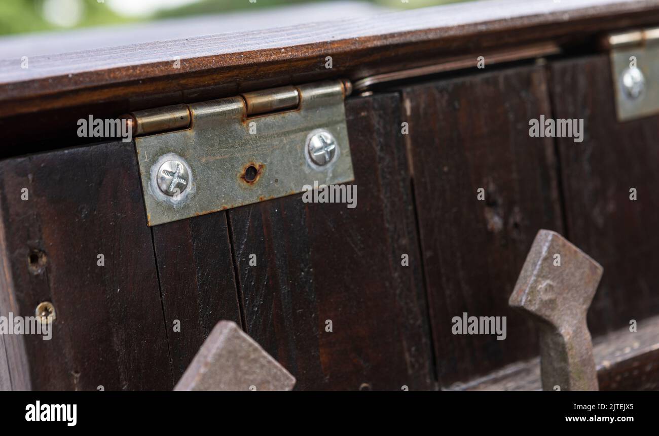 Cerniera in metallo avvitata al legno - cerniera in ottone su teak Foto Stock