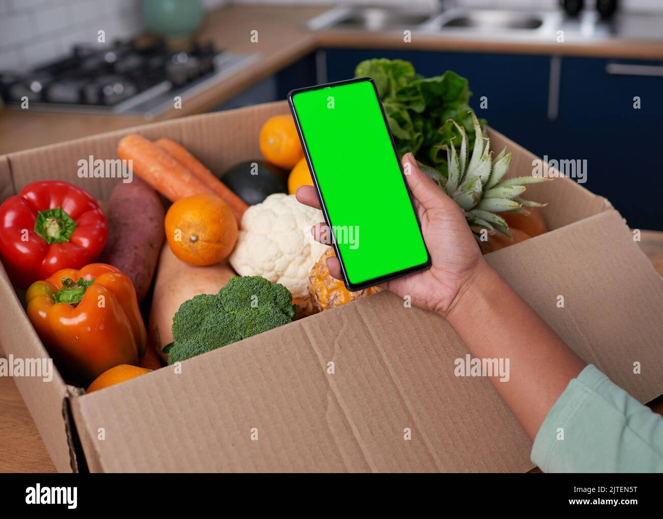 Un primo piano dello schermo del telefono cellulare con la consegna della scatola di verdura - chiave croma Foto Stock