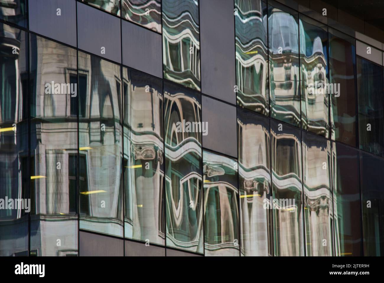 Gli uffici di Manchester si riflettono in una finestra di vetro per mimare motivi astratti Foto Stock