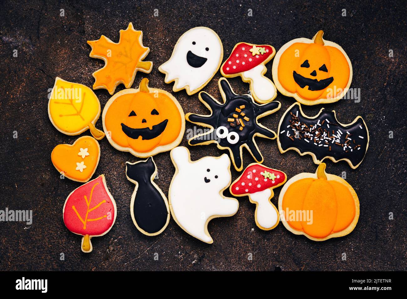 Vista dall'alto di molti biscotti allo zucchero di Halloween con glase - jack di zucca, funghi, gatto nero, fantasmi, ragno, bat Foto Stock
