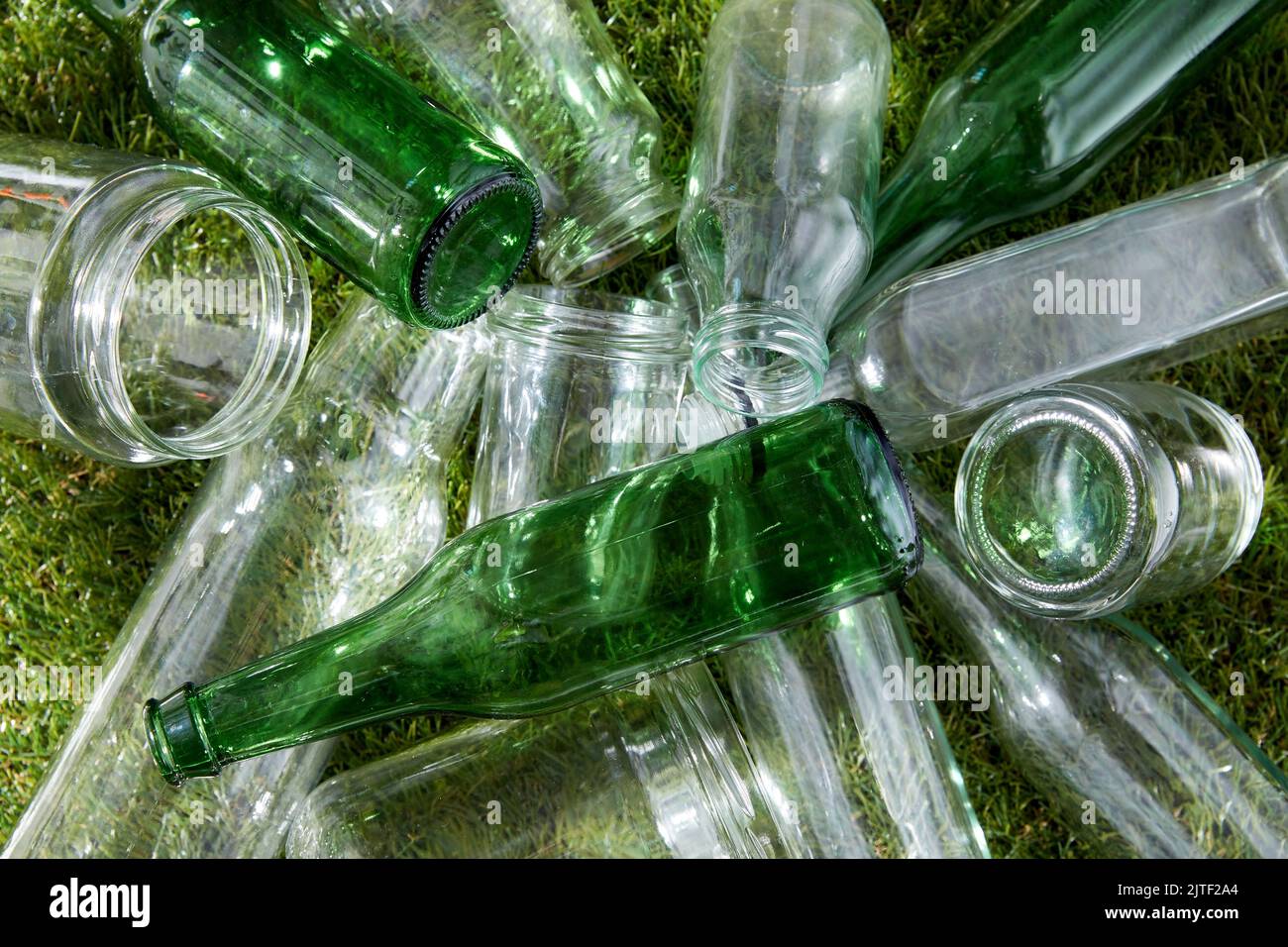 primo piano di bottiglie di vetro vuote e vasetti sull'erba Foto Stock
