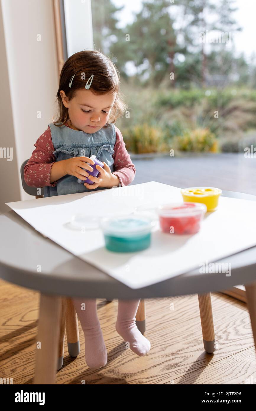 bambina con argilla modellante che gioca a casa Foto Stock