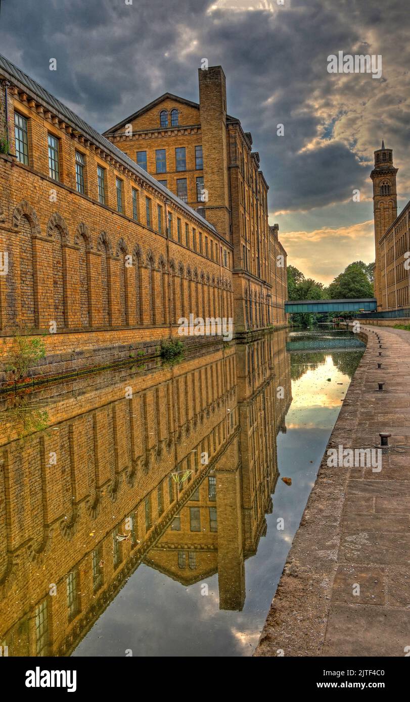 Salts Mill, fabbrica tessile, di Leeds e Liverpool Canal, con Reflection, Saltaire, Shipley, Bradford, West Yorkshire, Inghilterra, UK, BD18 3HU Foto Stock
