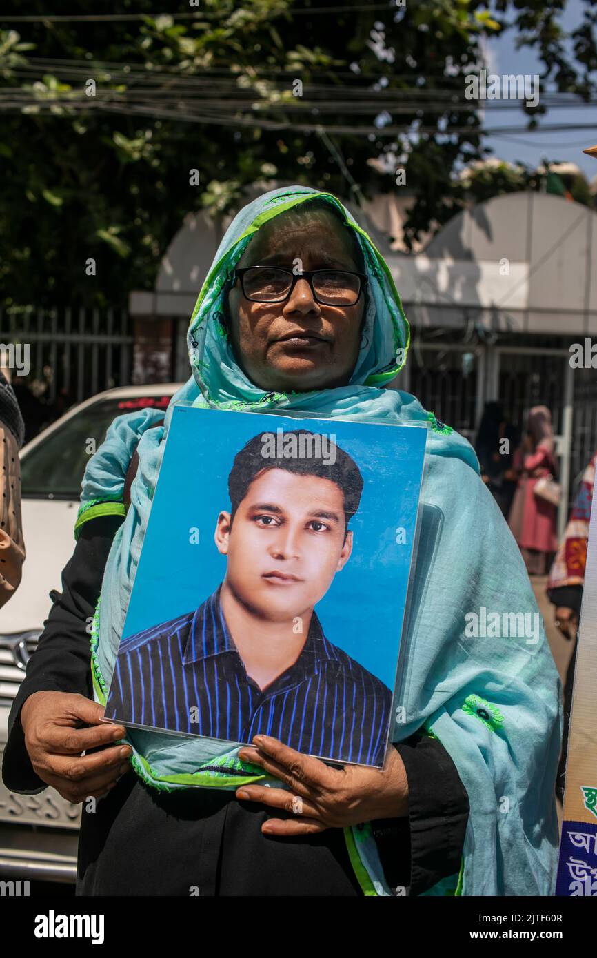 Dhaka, Bangladesh. 30th ago, 2022. Una donna tiene una foto del figlio scomparso durante la Giornata Internazionale delle vittime delle sparizioni forzate. I parenti delle vittime della sparizione forzata hanno chiesto il ritorno dei loro cari. Il nome dell'organizzazione sociale 'Mayer Dak' ha organizzato questo evento per celebrare la Giornata Internazionale dei scomparsi. Credit: SOPA Images Limited/Alamy Live News Foto Stock