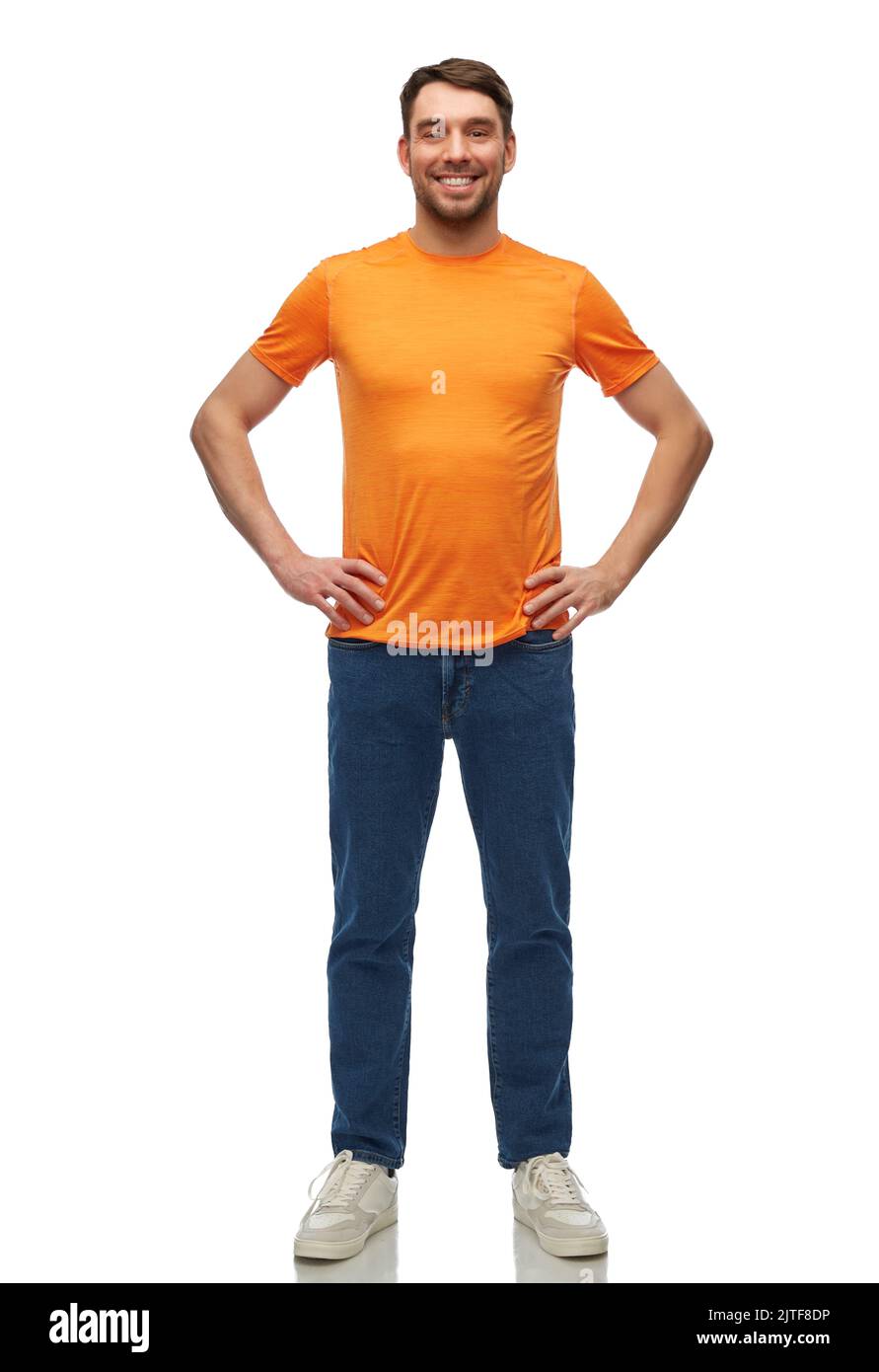 felice uomo sorridente in t-shirt arancione e jeans Foto Stock