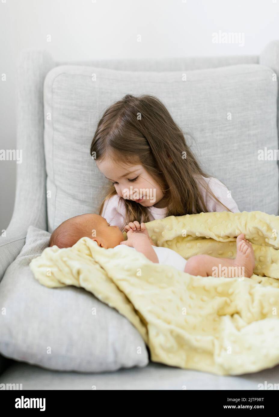 Sorella (2-3) che tiene il fratello del bambino (0-1 mesi) Foto Stock