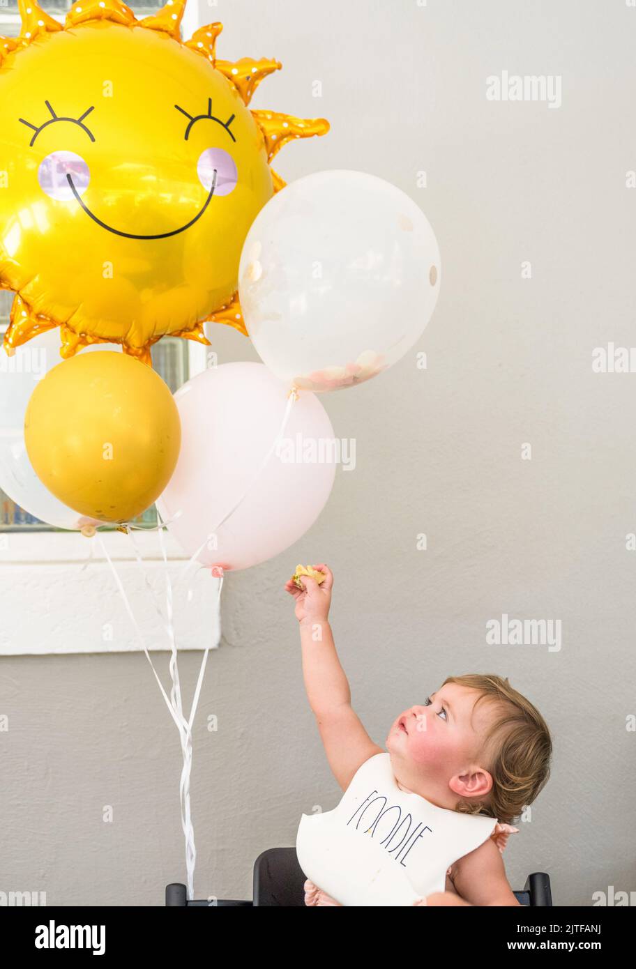 Bambina (12-17 mesi) con palloncini Foto Stock
