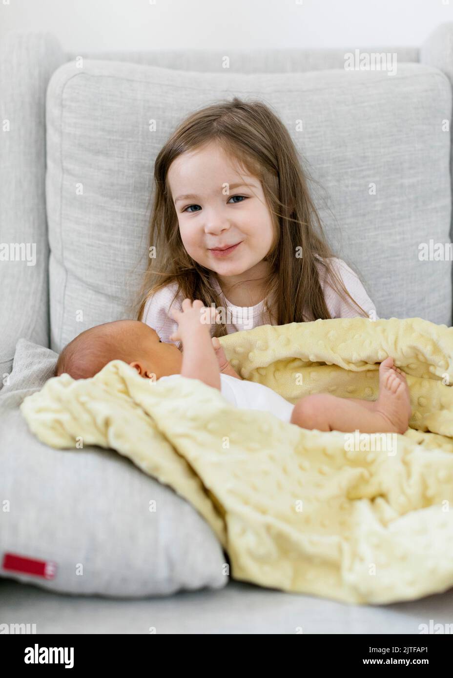 Ragazza (2-3) che tiene neonato fratello (0-1 mesi) Foto Stock