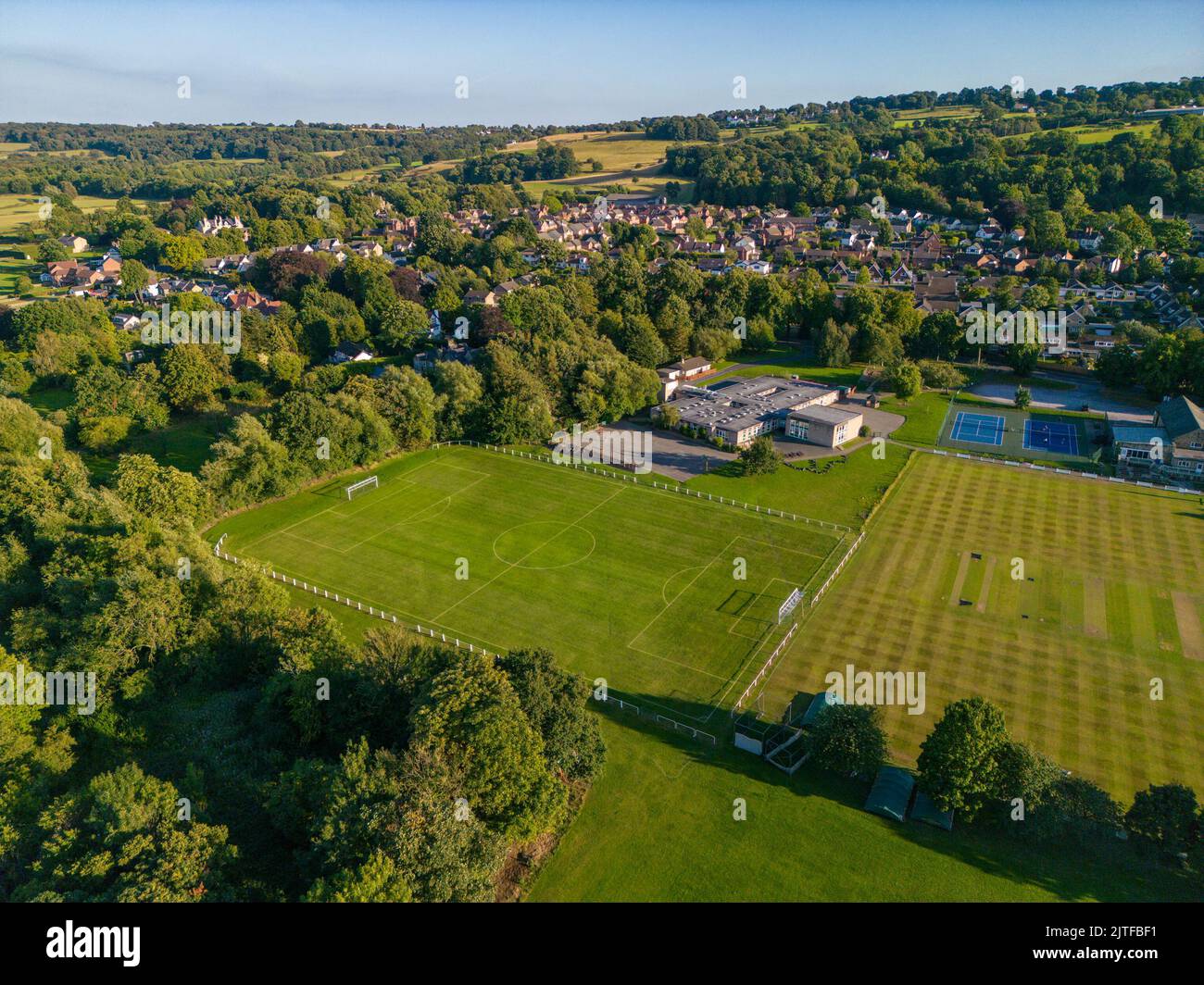 Vista aerea dei campi da gioco nella piscina di Wharfedale. Campo da calcio del villaggio, campo da cricket e scuola primaria di piscina. Foto Stock